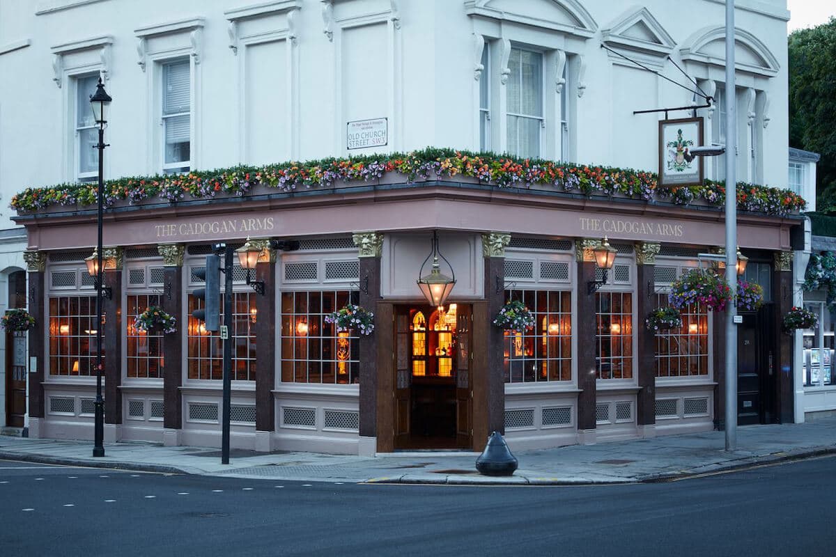 The wood panelled bar of a traditional London pub with taps and glasses